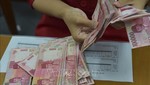 Kiểm đếm tiền giấy rupiah tại Indonesia. Ảnh: AFP/TTXVN