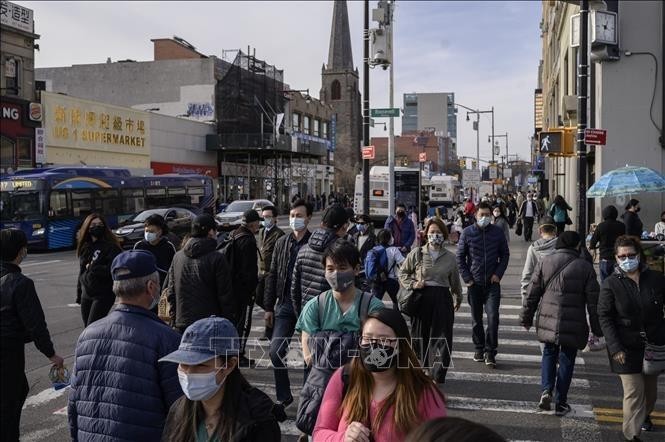 Người dân di chuyển trên đường phố tại New York, Mỹ. Ảnh: AFP/ TTXVN