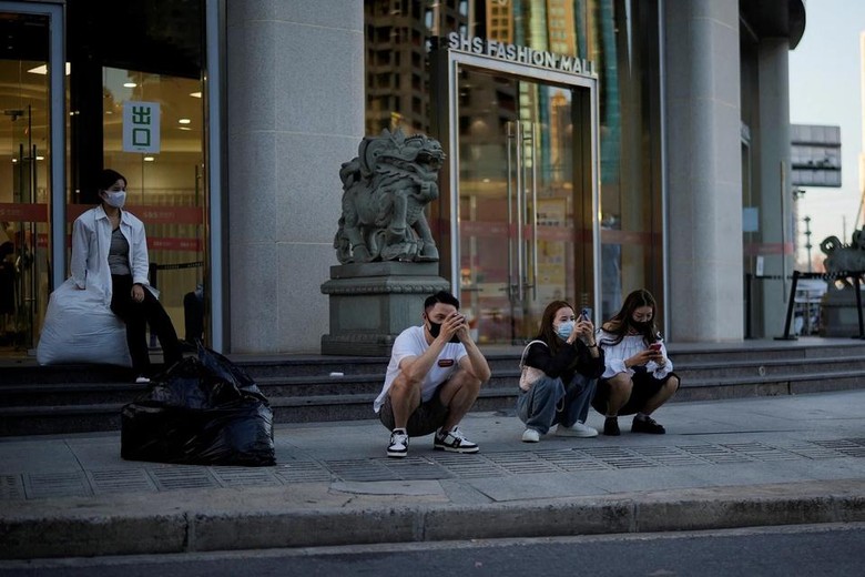 Một nhóm người trẻ ngồi bên ngoài trung tâm mua sắm ở Thượng Hải tháng 9/2022. Ảnh: Aly Song/Reuters.